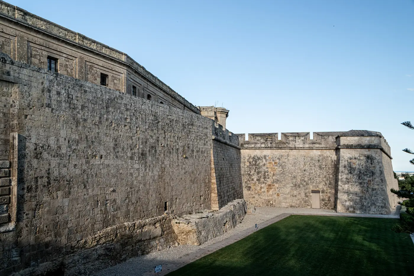 The southern bastion and stone walls of Mdina under a clear blue sky